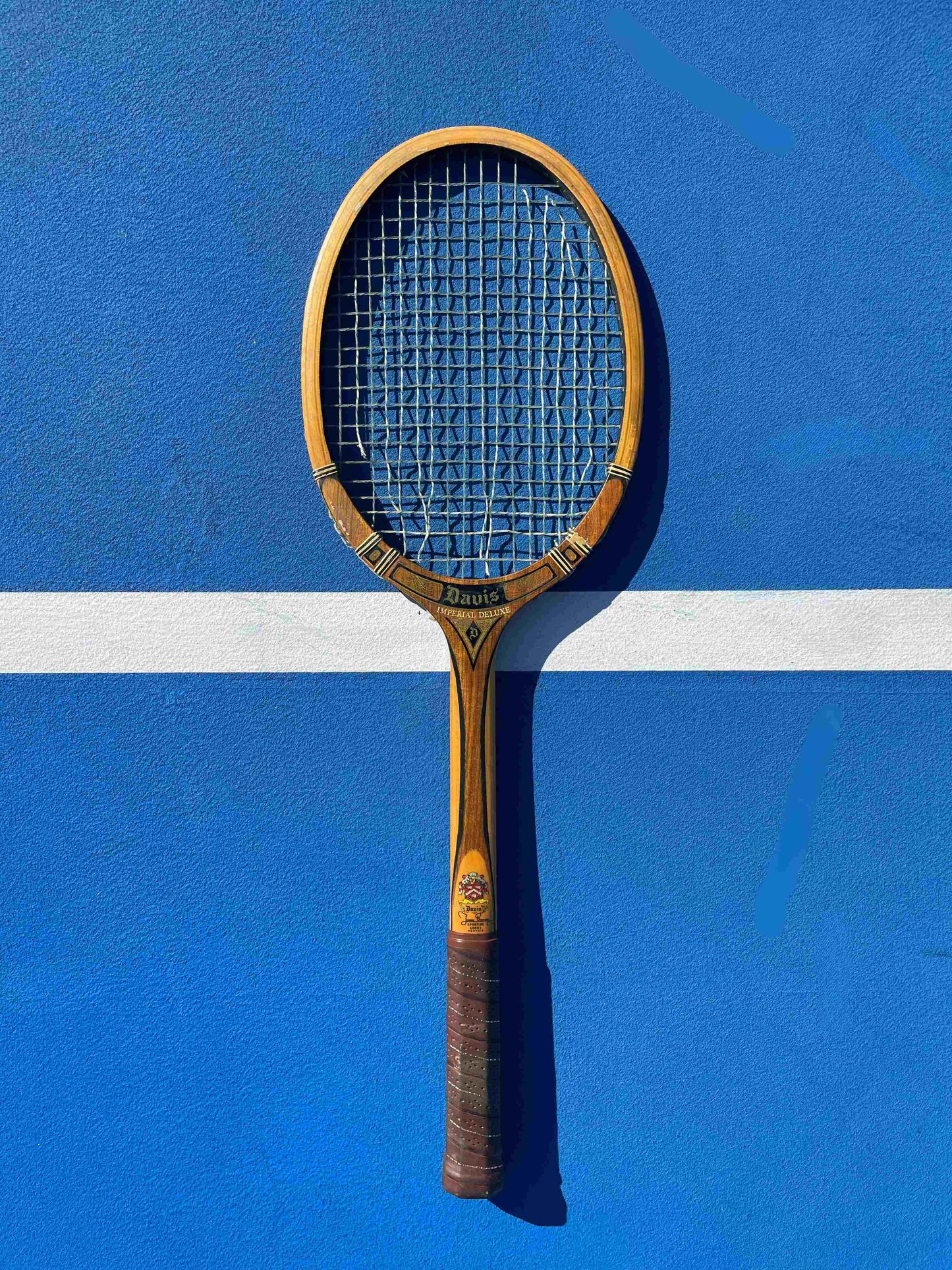 Vintage Tad Davis Imperial tennis racket on a blue tennis court