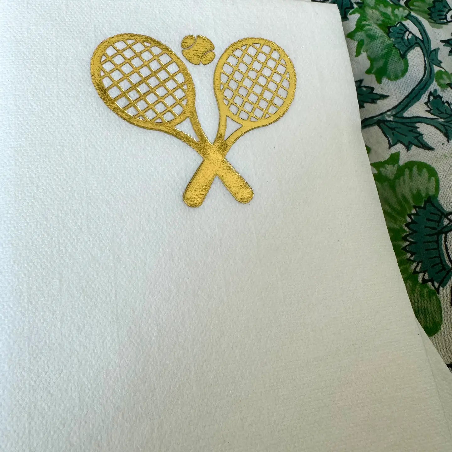 Cream linen guest napkins with gold tennis ball and racquets on Tennis DuJour.