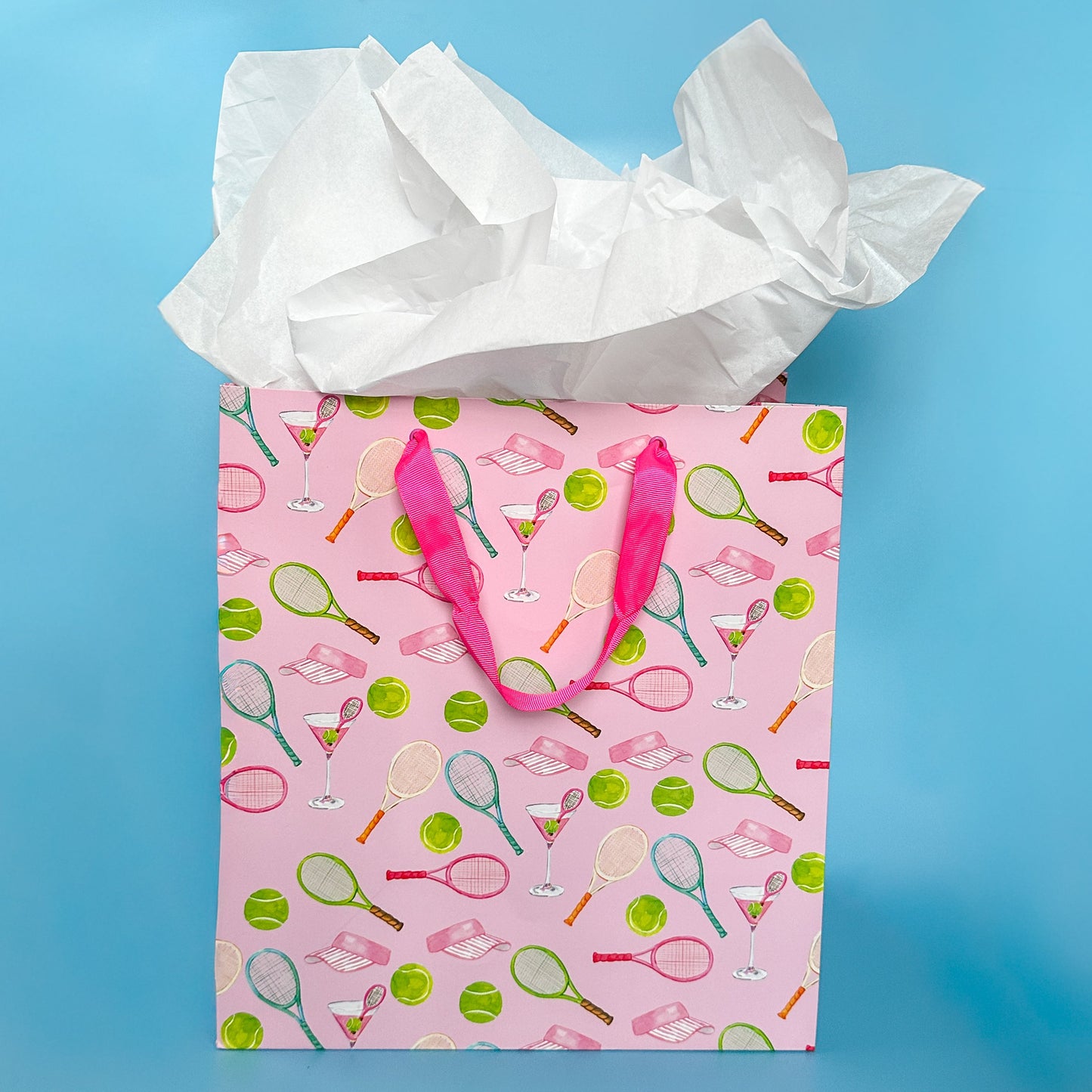Gift bag with tennis racket and cocktail pattern on a blue background