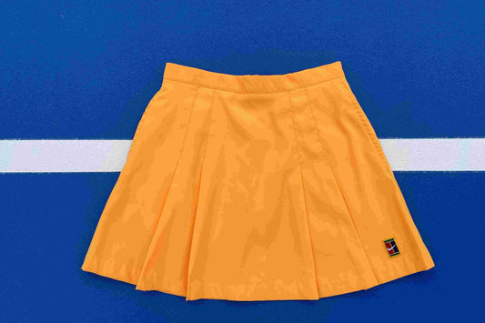 Yellow pleated skirt with a nike logo on a blue background