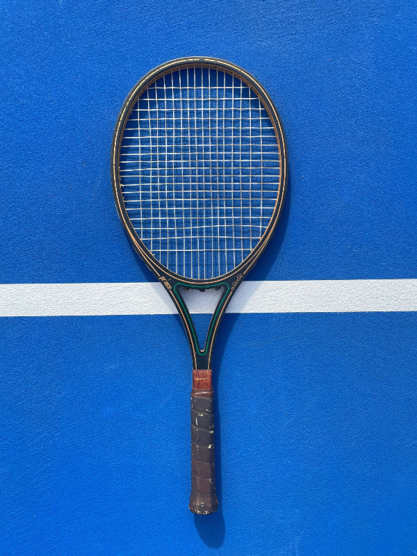 Tennis racket on a blue court with a white line