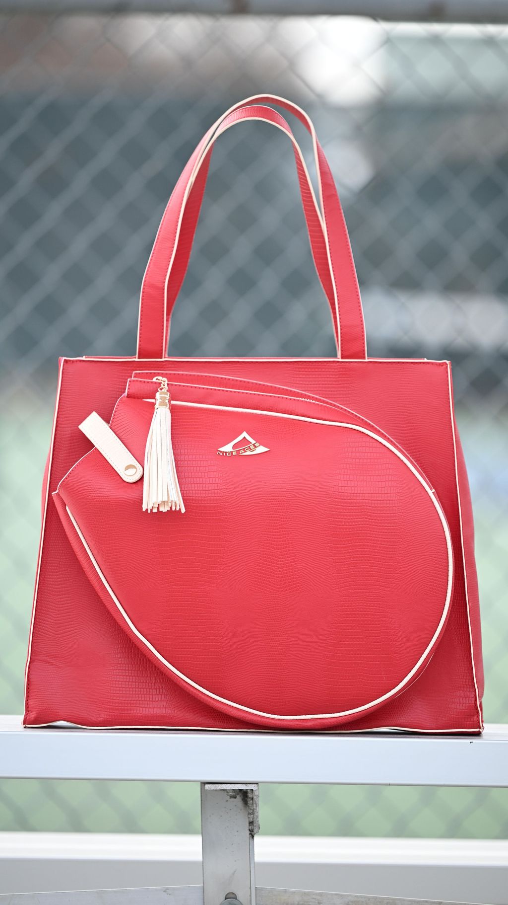 Red handbag with a tassel on a metal surface