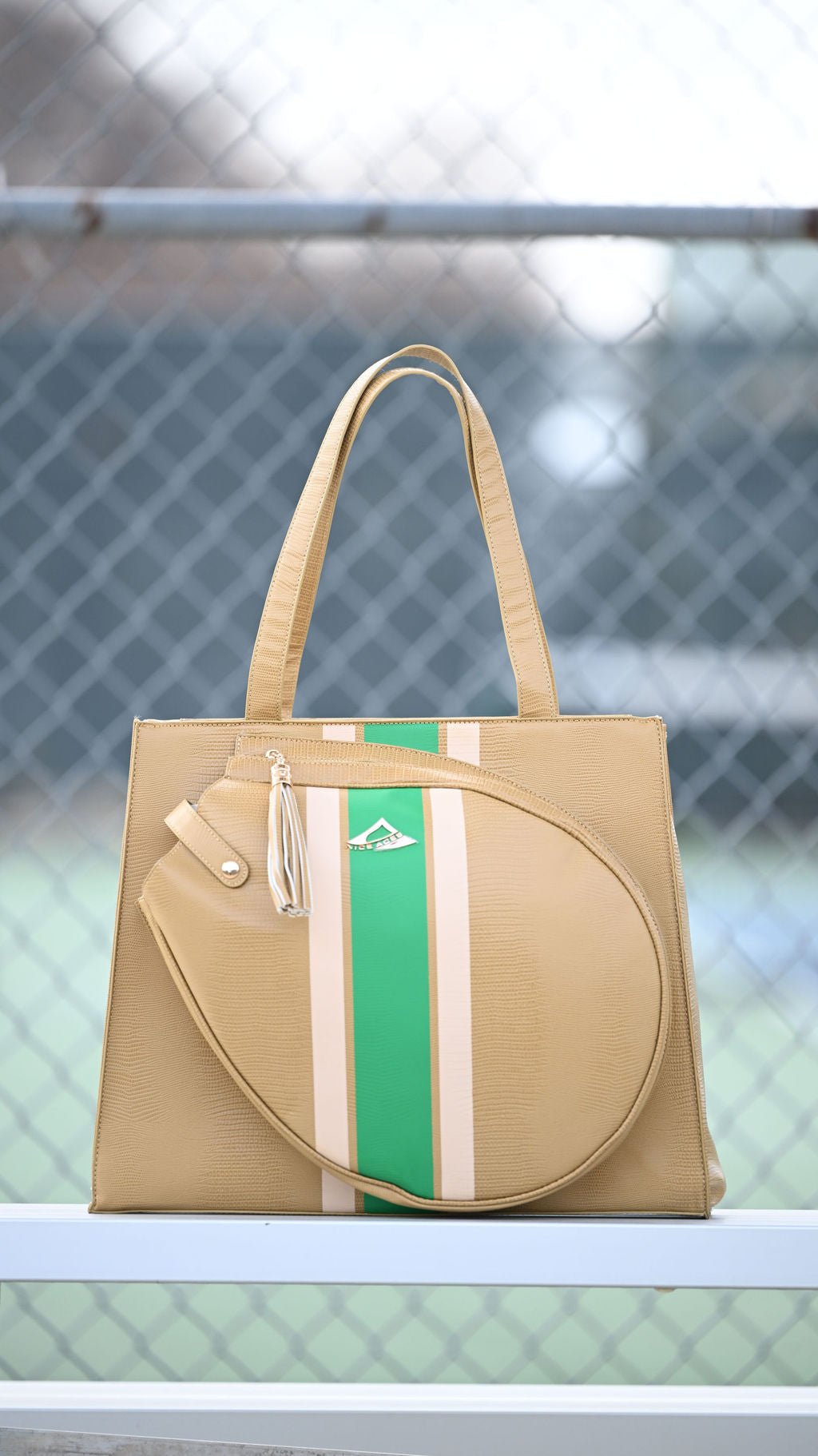 Beige tennis bag with green and white stripe on a blurred background