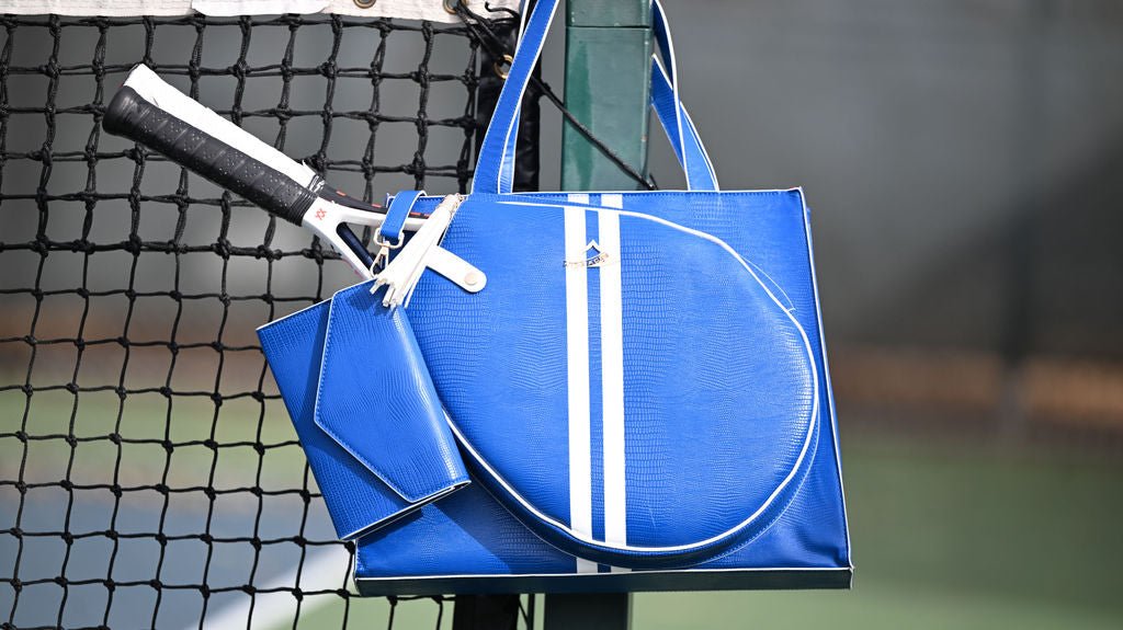 Blue paddle and paddle bag on a tennis court