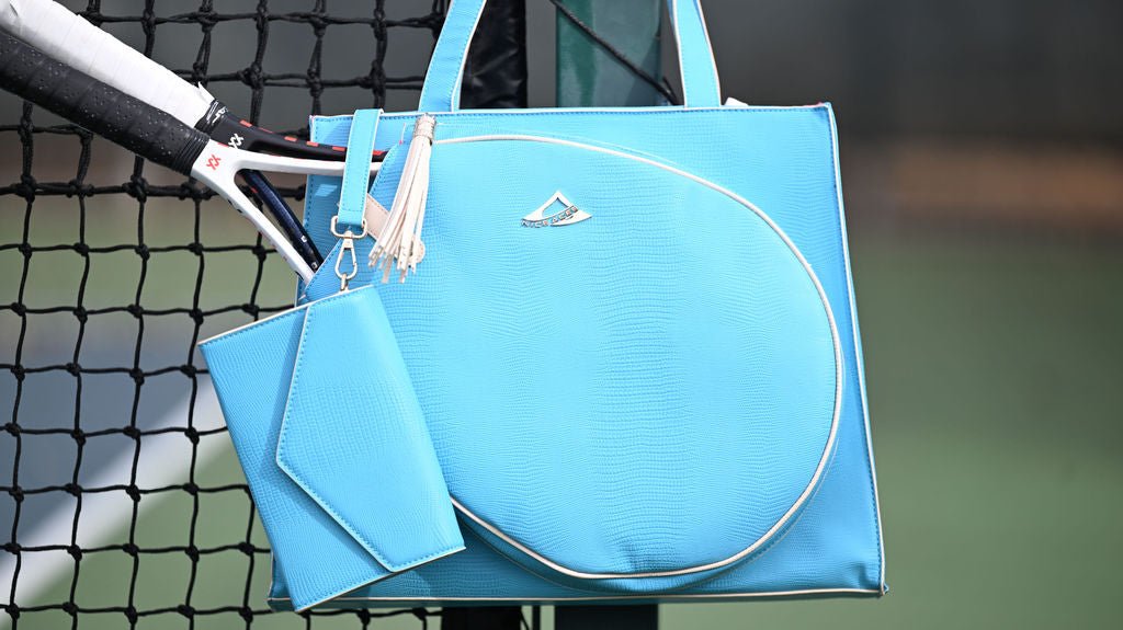 Blue tennis tote bag with a tennis racket on a tennis court
