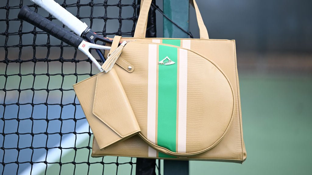 Beige handbag with green stripe on a tennis court