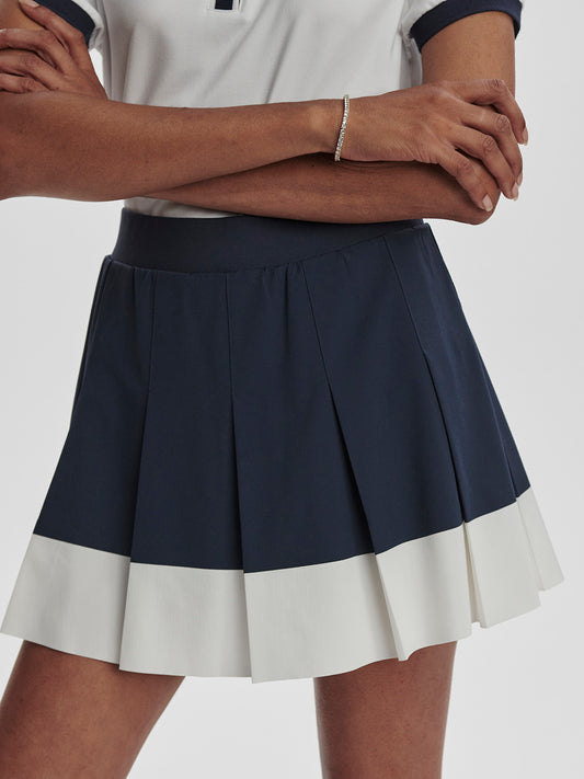Varley Chase Midrise tennis skort  in navy and white on model on TennisDuJour.com