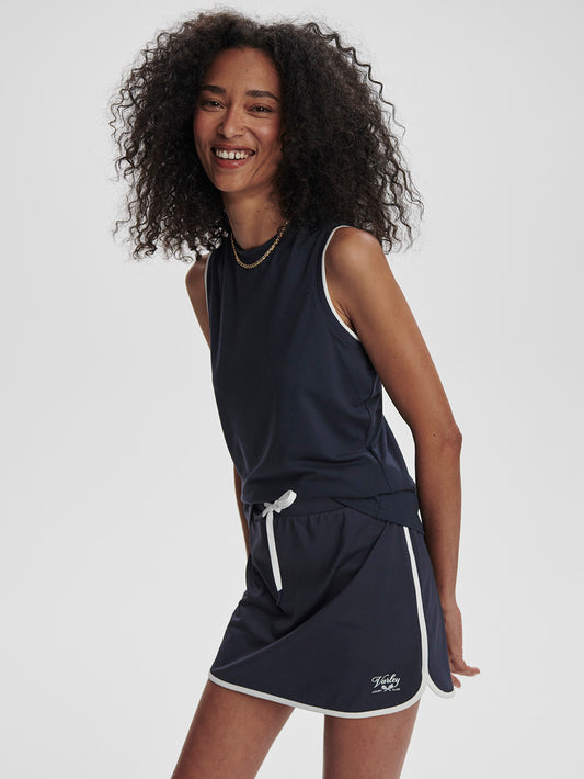 Model wearing Varley Archer Tennis Skort in Blue Nights on TennisDuJour.com.