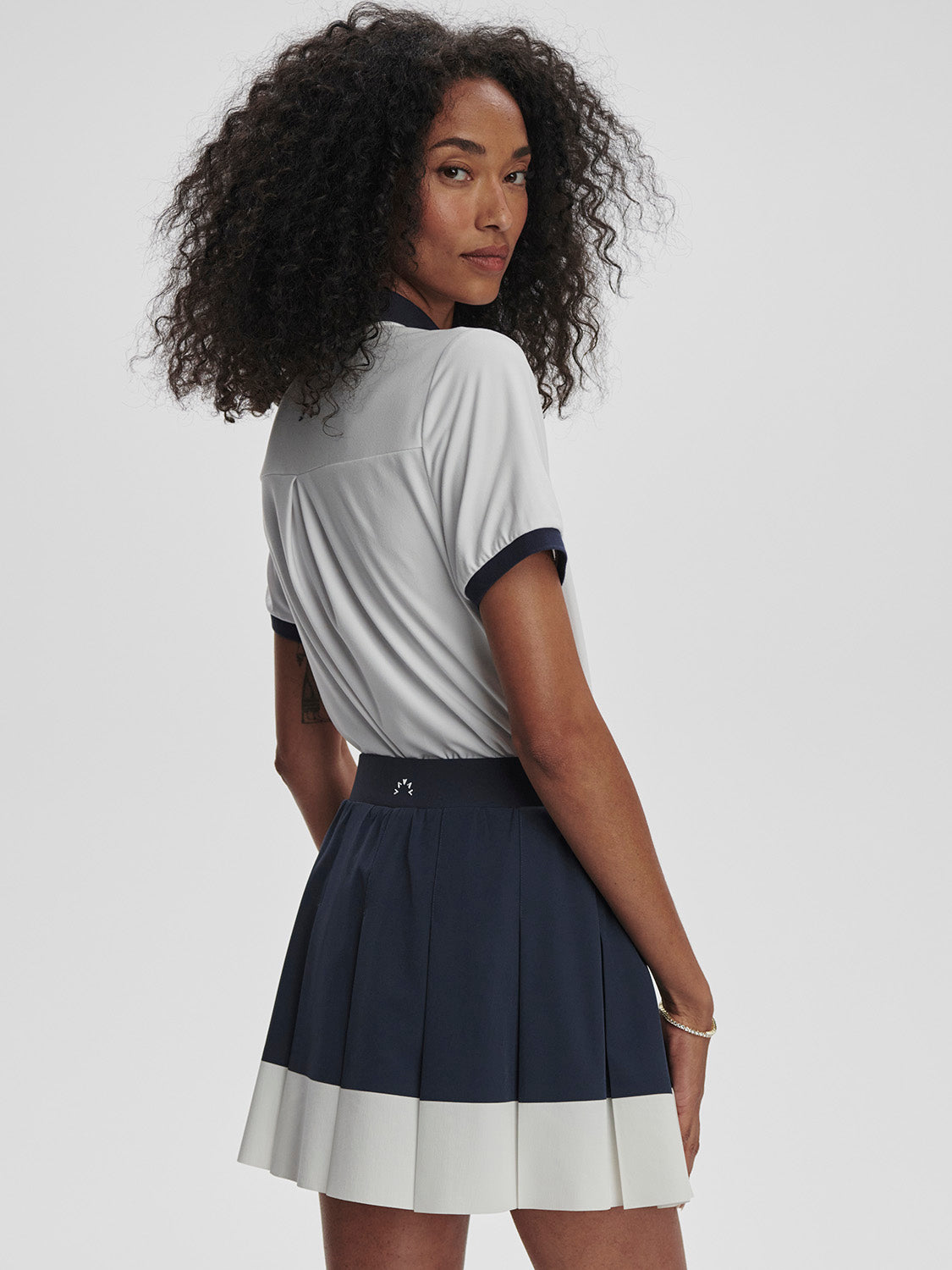 Varley Chase Midrise tennis skort  in navy and white on model on TennisDuJour.com